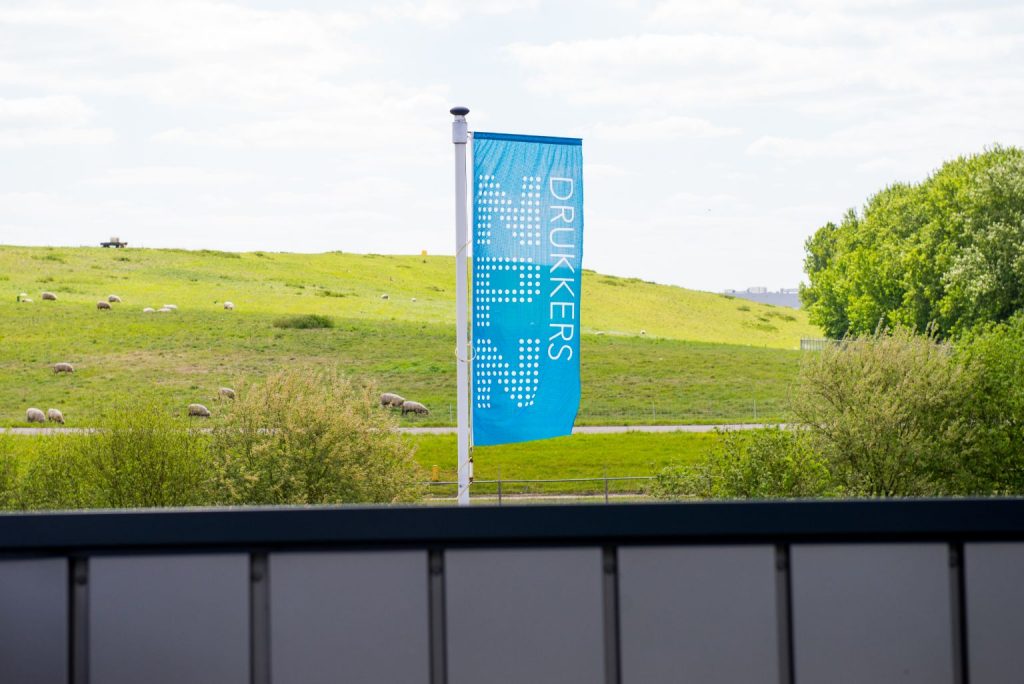 Flag NPN Drukkers with meadow in the background